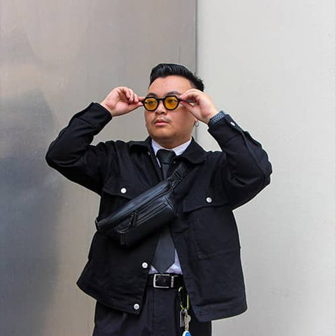 Man on a industrial background with a black streetwear bum bag from cawa.me