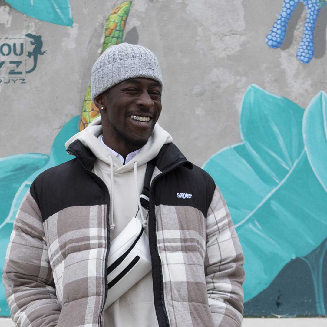 Man in an urban area with graffiti wearing the original streetwear bum bag from cawa.me