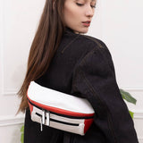 Woman wearing streetwear outfit with a white and red streetwear bum bag from cawa.me in a white room