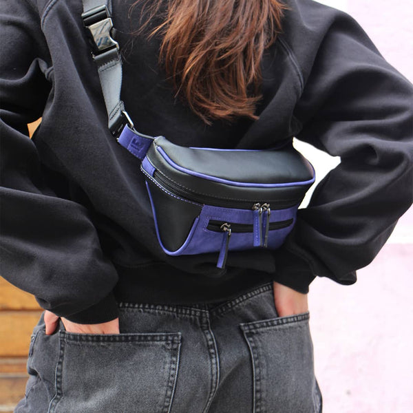 Woman in an urban area with a black and blue streetwear bum bag from cawa.me in streetwear outfit
