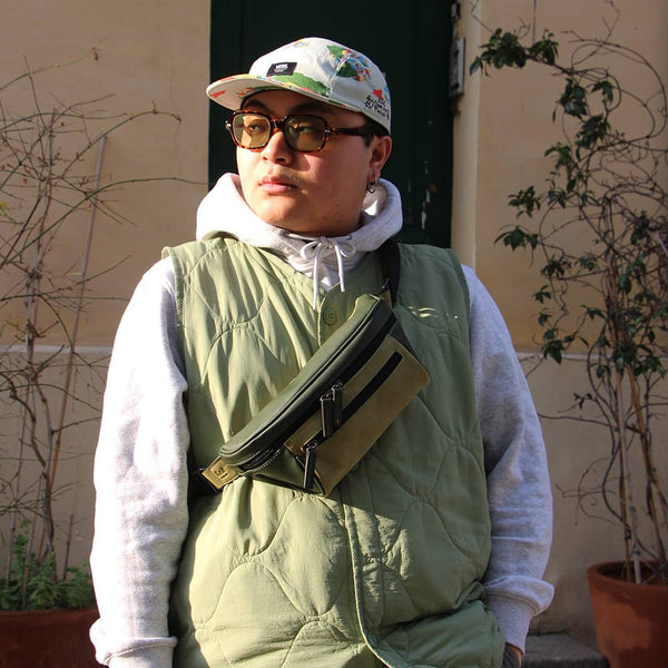 Man in an urban area with a green streetwear bum bag from cawa.me