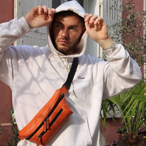 Man in an urban area with an orange streetwear bum bag